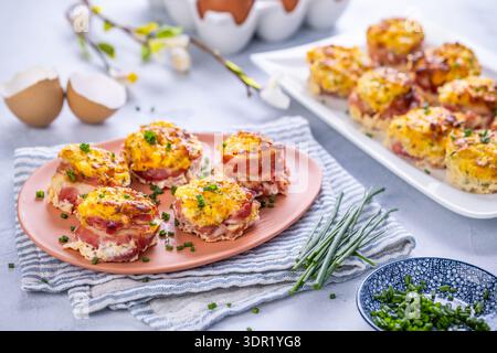 Bacon and eggs muffins for Easter brunch with chives Stock Photo