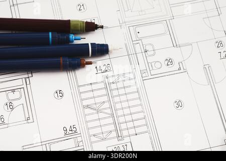 Collection of Architectural Plans With Pens and Drawings on a Table Stock Photo