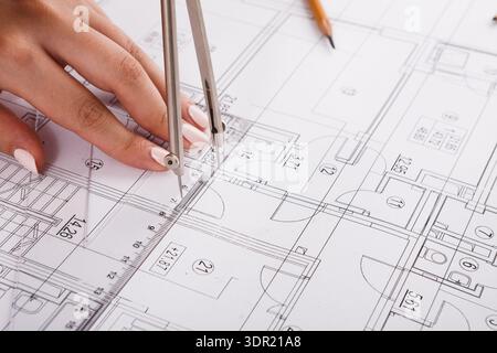 Hands Using Compass on Architectural Drawing to Create Accurate Measurements and Designs Stock Photo