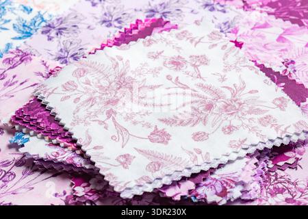 Fabric patchwork squares, in various colours and designs, stacked background backdrop. Sewing craft needlework concept. Stock Photo