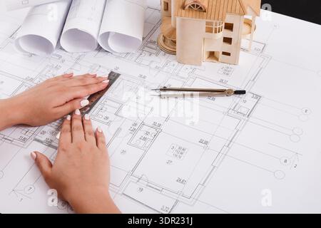 Collage of Hands Working on Architectural Plans With Model and Tools on Desk Stock Photo