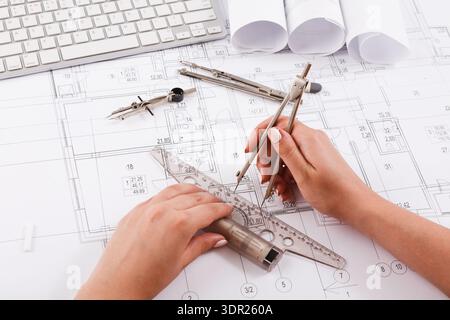 Hands Creating a Technical Drawing on Blueprint Layout With Tools and Plans Around Stock Photo