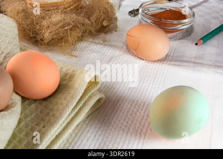 Chicken eggs with wax drawing tools and natural dye for Easter decoration Stock Photo