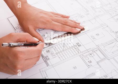 Hands Measuring a Blueprint During a Design Project in an Architectural Workspace Stock Photo