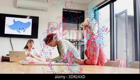 Collaborating three women at wood conference table in office attire, with laptop and mantaray TV Stock Photo