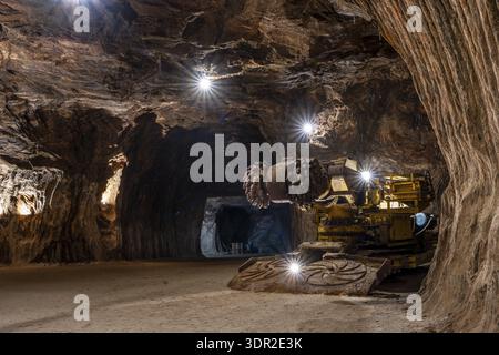 Tunnel boring machine operating inside an underground rocksalt mine in Loule, Algarve, showcasing heavy mining equipment, rugged mineral walls, and d Stock Photo