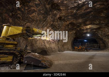 Tunnel boring machine operating inside an underground rocksalt mine in Loule, Algarve, showcasing heavy mining equipment, rugged mineral walls, and d Stock Photo