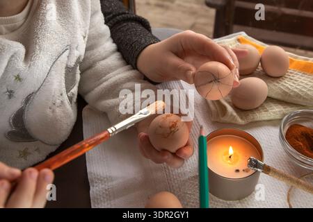 Wax decoration process of Easter eggs using traditional pysanka technique with natural spice dye at home Stock Photo