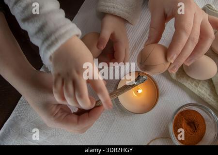 Wax decoration process of Easter eggs using traditional pysanka technique with natural spice dye at home Stock Photo