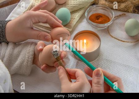 Wax decoration process of Easter eggs using traditional pysanka technique with natural spice dye at home Stock Photo