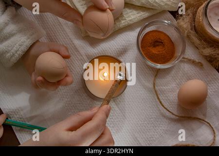 Wax decoration process of Easter eggs using traditional pysanka technique with natural spice dye at home Stock Photo