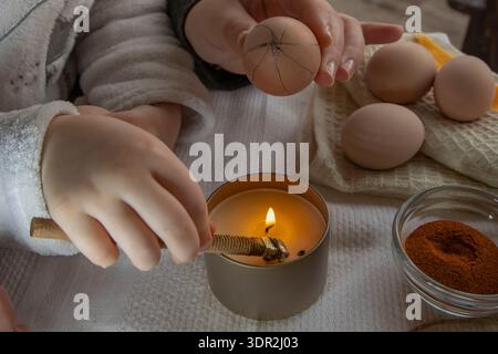 Wax decoration process of Easter eggs using traditional pysanka technique with natural spice dye at home Stock Photo