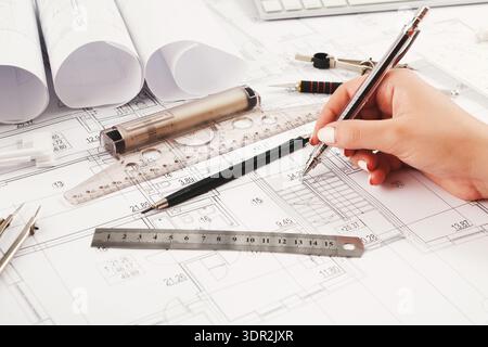Collection of Drafting Tools and Plans Displayed on a Workspace Desk During an Architectural Project Stock Photo
