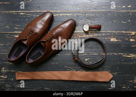 Male shoes with accessories on black wooden background Stock Photo