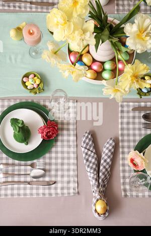 Easter table setting with flowers, napkin, painted egg and Easter bunny Stock Photo