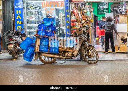 Large blue plastic water bottles being delivered by motorbike in Hanoi, Vietnam. Stock Photo
