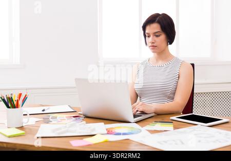 Woman Working on Laptop in a Bright Office During Daytime Stock Photo