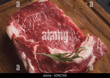 Fresh Raw Beef Steak With Herbs on Wooden Cutting Board for Cooking Preparation Stock Photo