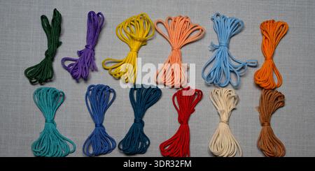 Assorted colorful cord bundles arranged in flat lay composition, craft supplies and DIY materials concept, textile accessories for macrame, sewing, de Stock Photo