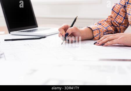 Design Work in a Modern Office With Plans and a Laptop on a Table Stock Photo