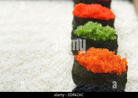 Different Types of Sushi Rolls With Various Toppings Placed on a Bed of White Rice Stock Photo