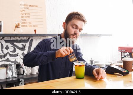 Barista Prepares Colorful Drink in Coffee Shop During Afternoon Shift Stock Photo