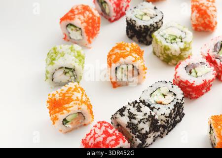 Colorful Sushi Rolls on White Plate Arranged in Various Patterns and Styles Stock Photo