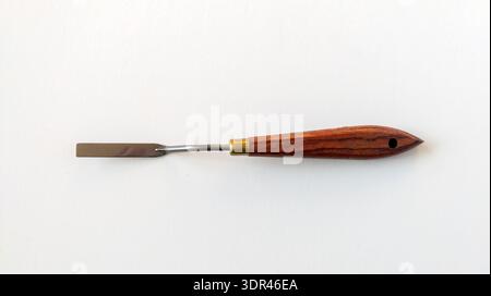 Flat palette knife with a wooden handle, top view. Art supplies for oil and acrylic painting, isolated on white background. Stock Photo