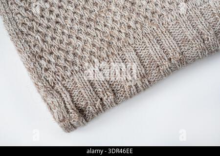 Folded knitted gray wool blanket. Edge of the gray knitted blanket on a white background. Top view flat lay Stock Photo