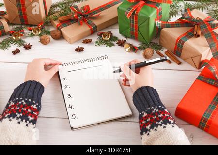 Making a Holiday Gift List With Presents and Decorations Around a Cozy Setting Stock Photo