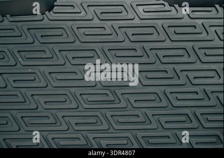 Abstract background of a dark, textured surface with a repeating geometric pattern Stock Photo