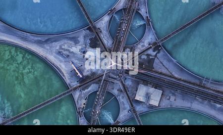 Aerial view of vibrant turquoise and emerald pools intersect with complex industrial architecture, creating a stunning geometric landscape., Bagdad, A Stock Photo