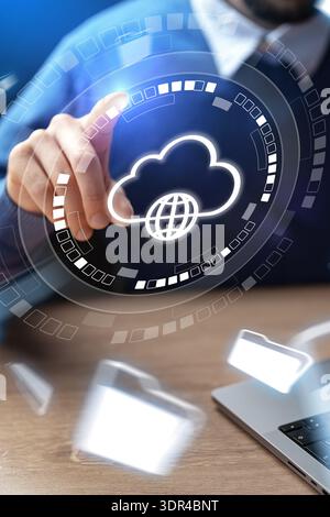 Man interacts with cloud symbol on digital interface at office desk in daylight Stock Photo