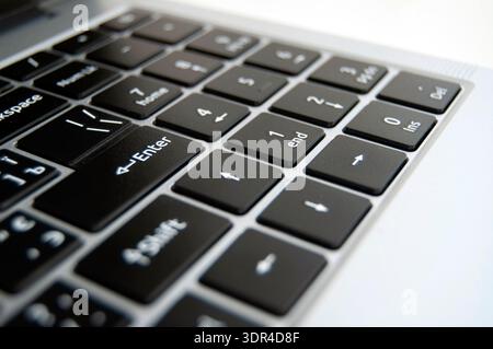 A close-up of a laptop keyboard. Enter key highlighted background. A laptop keys background. Stock Photo