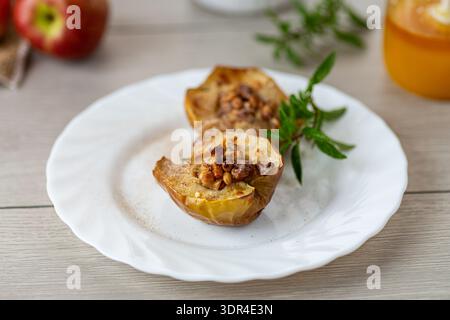 Baked apples with honey and nuts on white plate. Stock Photo
