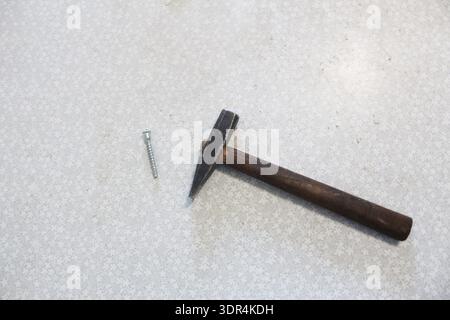 a hammer and a nail on a white background. The concept of no construction tools. Stock Photo
