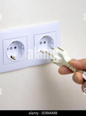 The man plugs in the cord. Selective focus. Stock Photo