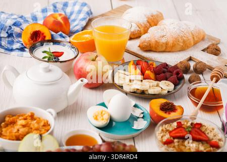 Collection of Breakfast Foods and Drinks Arranged on a Wooden Table in a Bright Setting Stock Photo