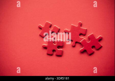 Red jigsaw puzzle pieces on red background symbolizing teamwork, connection and problem solving concept Stock Photo