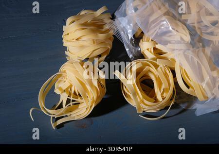 dried tagliatelle pasta in plastic packaging Stock Photo