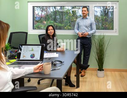 Diverse business team collaborating during an office meeting in coworking office located on forest Stock Photo
