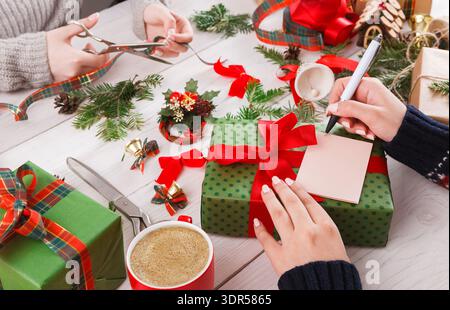 Holiday Gift Wrapping and Crafting Session With Friends on a Wooden Table Stock Photo