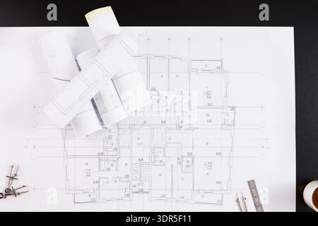 Collection of Architectural Plans and Tools on a Black Surface During a Design Session Stock Photo