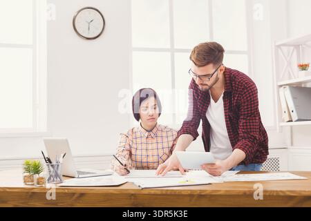 Team Members Discuss Project Details in Office Environment During Afternoon Hours Stock Photo