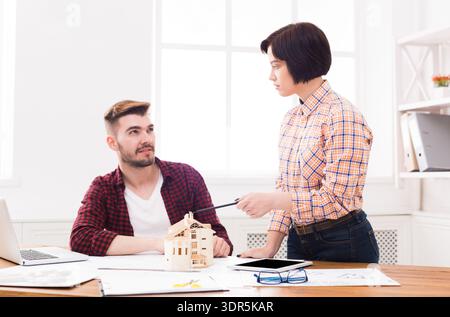 Discussion on Architectural Model in Bright Office Space With Two Designers at Work Stock Photo