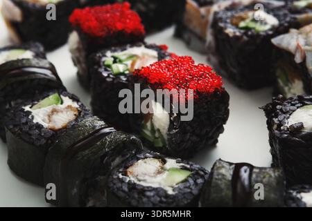 Sushi Rolls With Various Toppings Served on a White Plate During Lunch Stock Photo