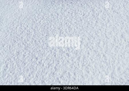 Minimalist winter texture featuring long blue shadows on pristine white snow. Stock Photo