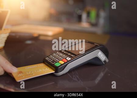 Close-up personal perspective of a Person paying with a  credit card using a credit card terminal Stock Photo