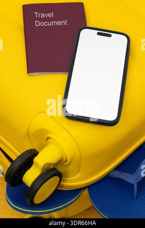 Close up of yellow suitcase corner with smartphone and travel document. Summer vacation concept with minimal composition and copy space. Stock Photo