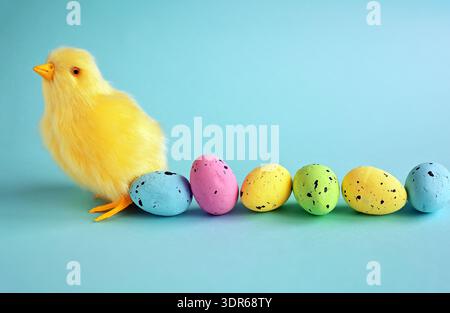 Easter decoration of a yellow chick with a row of colorful painted Easter eggs Stock Photo